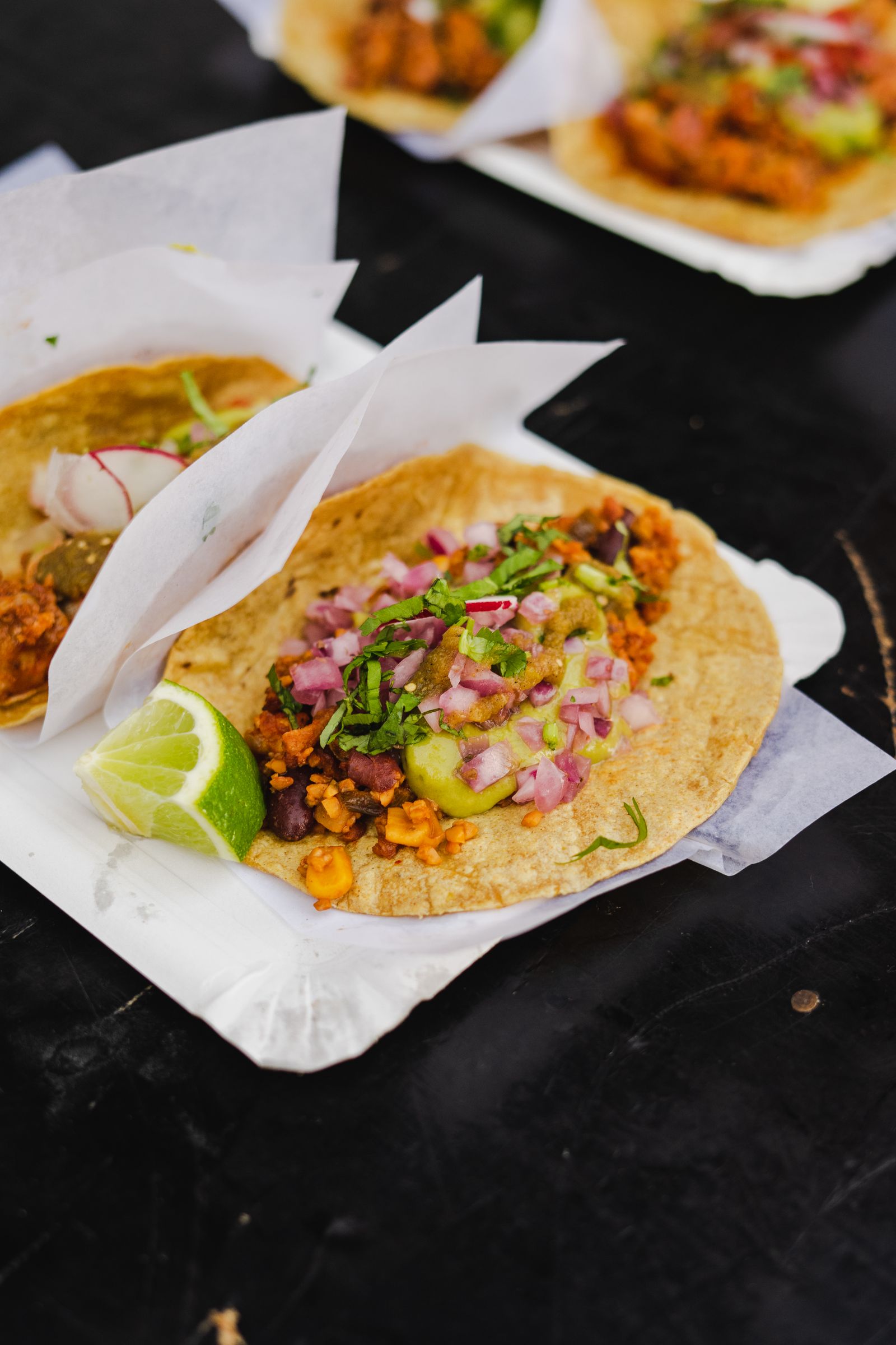 Tacos de birria recién servidos con consomé y limón